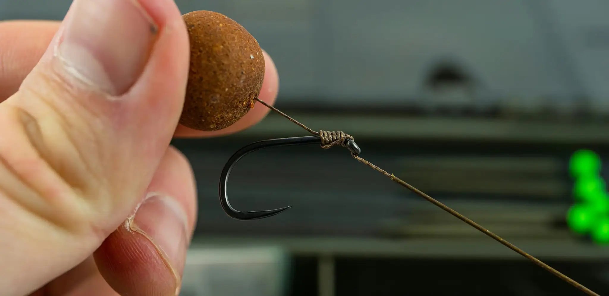 Brown textured bait pellet on black hook in BASIX Hair Rig setup