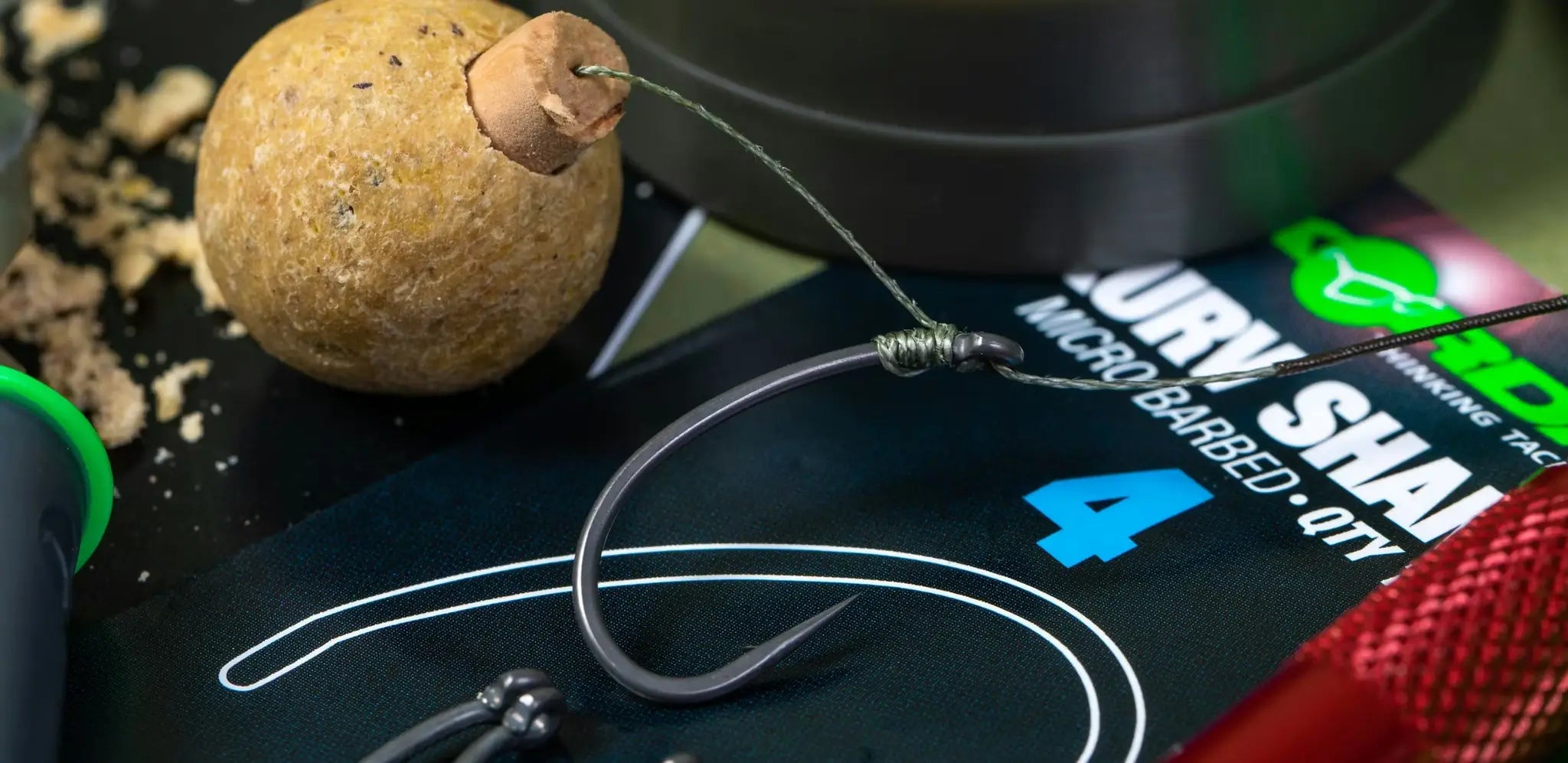 Black curved barbed fishing hook with wire-wound eye for Muzza rig