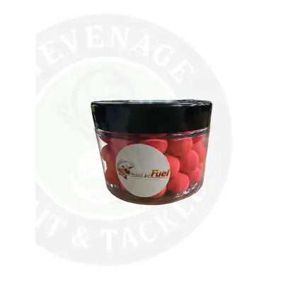 A clear plastic container with a black lid filled with bright red carp fuel pop up bait pellets for fishing use