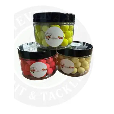 Three clear plastic jars of carp fuel pop ups in yellow red and pale yellow fishing bait balls with black lids