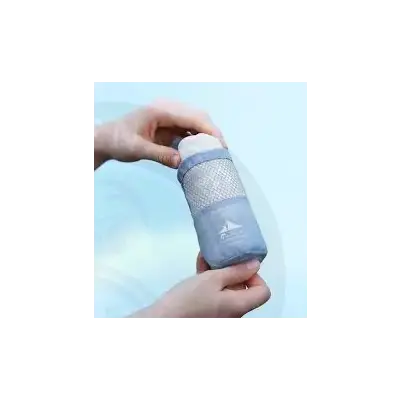 Light blue mesh wrapped water bottle with white cap and subtle sailboat logo featured with flextail cozy towel