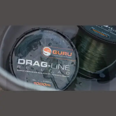 Guru drag-line 10lb black monofilament fishing line spool 30mm 1000m with orange label and water droplets from stevenage bait