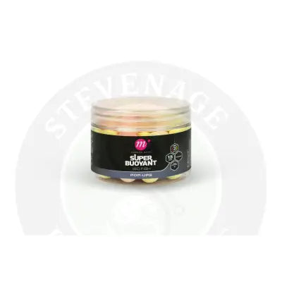 A clear plastic jar filled with mainline carp super buoyant pop-ups 13mm in pink white and yellow colors