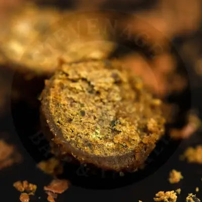 A round textured golden brown pellet with visible dark specks from sticky baits krill active freezer with amino acids