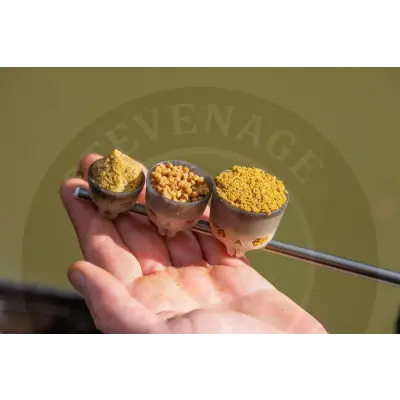 Three skull-shaped tackle guru-fast release pole pots in yellowish-brown filled with fish food pellets and powder