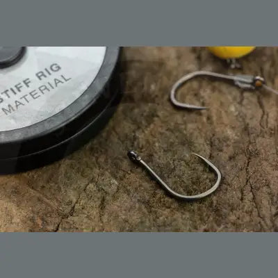 A metallic curved fishing hook with a sharp point and eyelet for tackle guru feeder box shallow fishing
