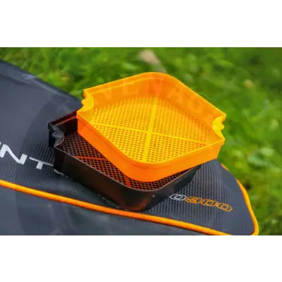 Bright orange hexagonal plastic guru maggot riddle with perforated grid surface and black mesh base by tackle guru