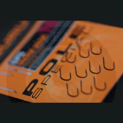 Black metal fishing hooks on orange tackle guru pole special packaging with bold lettering stevenage bait