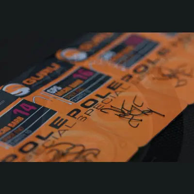 Orange packaging of guru brand fishing hooks pole special with black and pink text and a handwritten note for stevenage bait