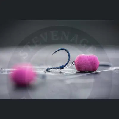 A vibrant pink textured bait pellet attached to a dark blue fishing hook featuring 0.3mm silicone tubing by tackle guru