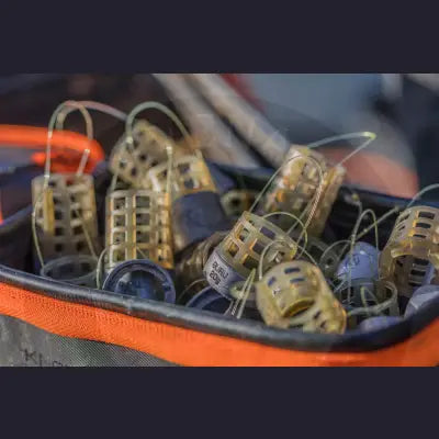Translucent yellow plastic tackle guru slimline x-change distance feeder cages with metal handles and black rubber bases