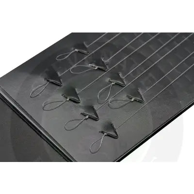 Black triangular smwg standard fishing hooks with small metal rings arranged on textured surface by tackle guru hooklength option