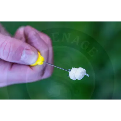 A hand holding a tackle guru speedstop fishing hook with yellow handle and white stevenage bait for baiting time
