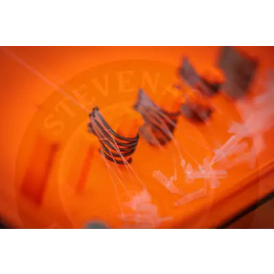 Orange plastic fishing lure with black wire coils and orange accents from tackle guru for stevenage bait baiting time