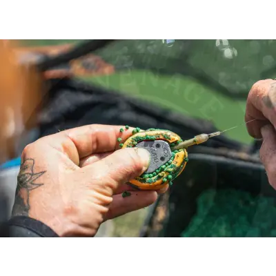 A yellow and green fishing float with a metallic base and needle attachment for tackle guru x-safe spare tail rubbers